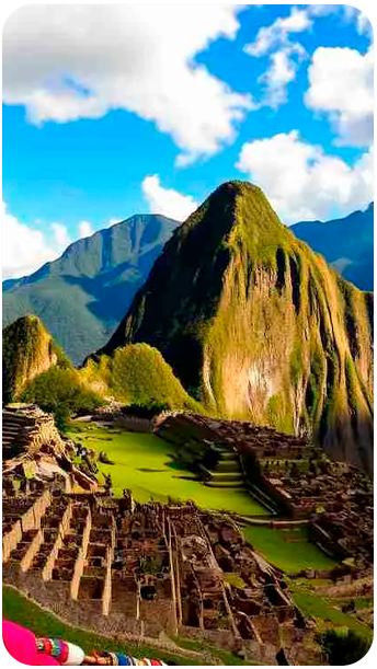 Vista panorâmica de Machu Picchu em um dia ensolarado, com as ruínas incas e montanhas ao fundo — destino imperdível nos passeios em Cusco, Peru com a Fui Gostei Trips.