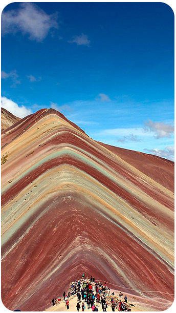 Turista sorridente no impressionante sítio arqueológico de Moray, em Cusco, com seus terraços circulares incas usados para experimentos agrícolas — uma das paradas culturais da Fui Gostei Trips no Peru.