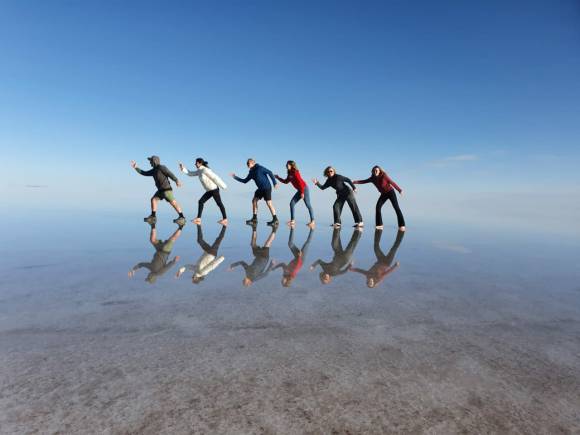 Grupo com reflexo no Salar de Uyuni espelhado