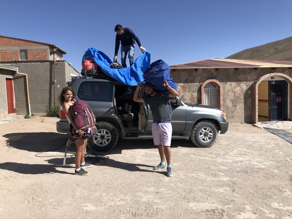 O que levar para o Salar de Uyuni? Três pessoas organizando as malas nos carros para o tour ao Salar