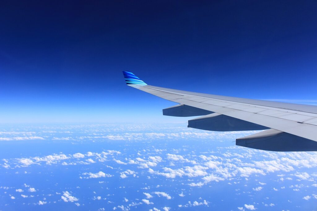 Asa de um avião no ar em um céu com nuvens