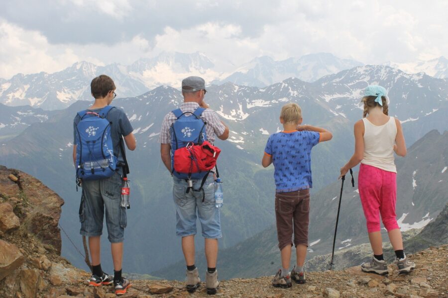 4 pessoas no alto de uma montanha, olhando outras montanhas