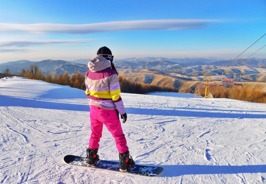 criança em uma paisagem de neve praticando esportes de neve