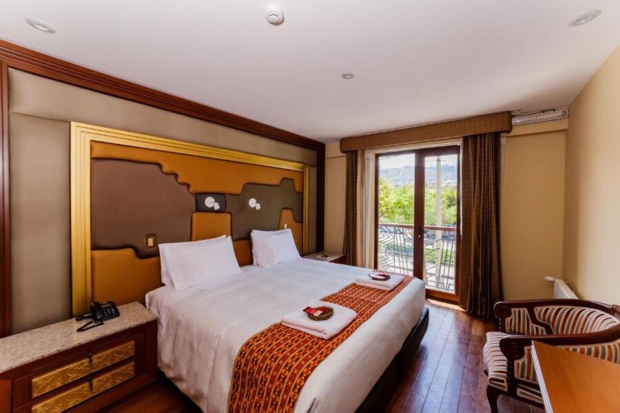 cama casal em um quarto em cusco, com quadro e janela para a sacada