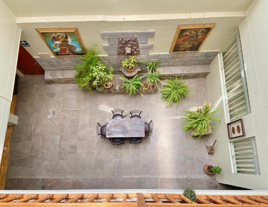 visão superior de estadia em cusco, com uma mesa, plantas e quadros nas paredes