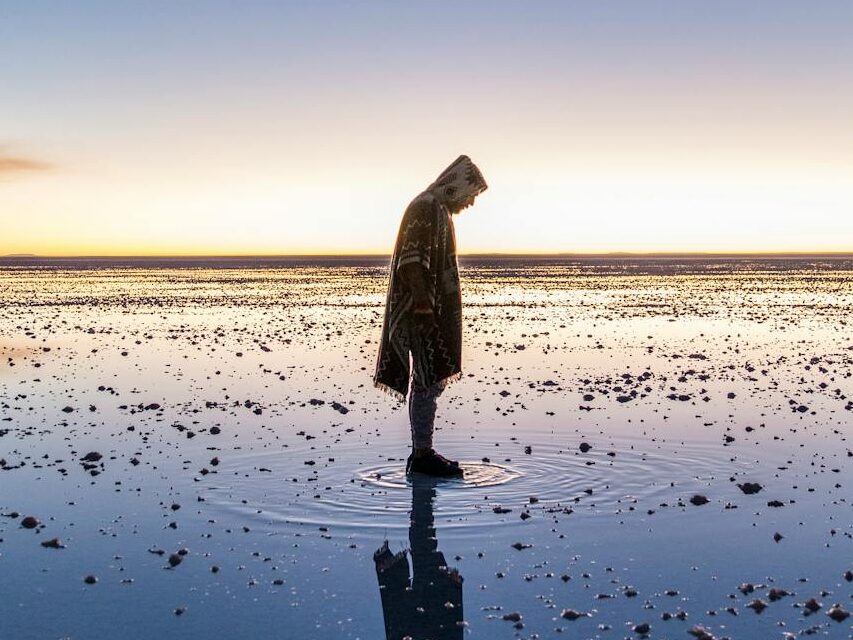 Pessoa se encantando com o reflexo gerado no salar de uyuni