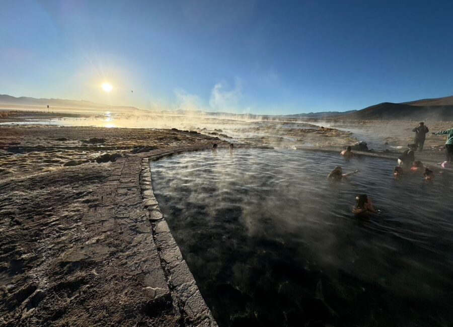 Pessoas relaxando em águas termais ao nascer do sol no Salar de Uyuni, cenário romântico ideal para lua de mel na Bolívia