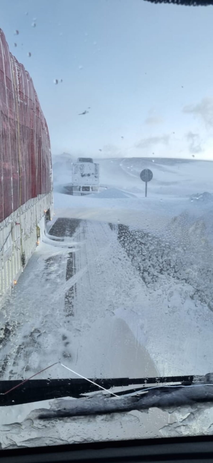 imagem de um retrovisor mostrando nevasca intensa no caminho