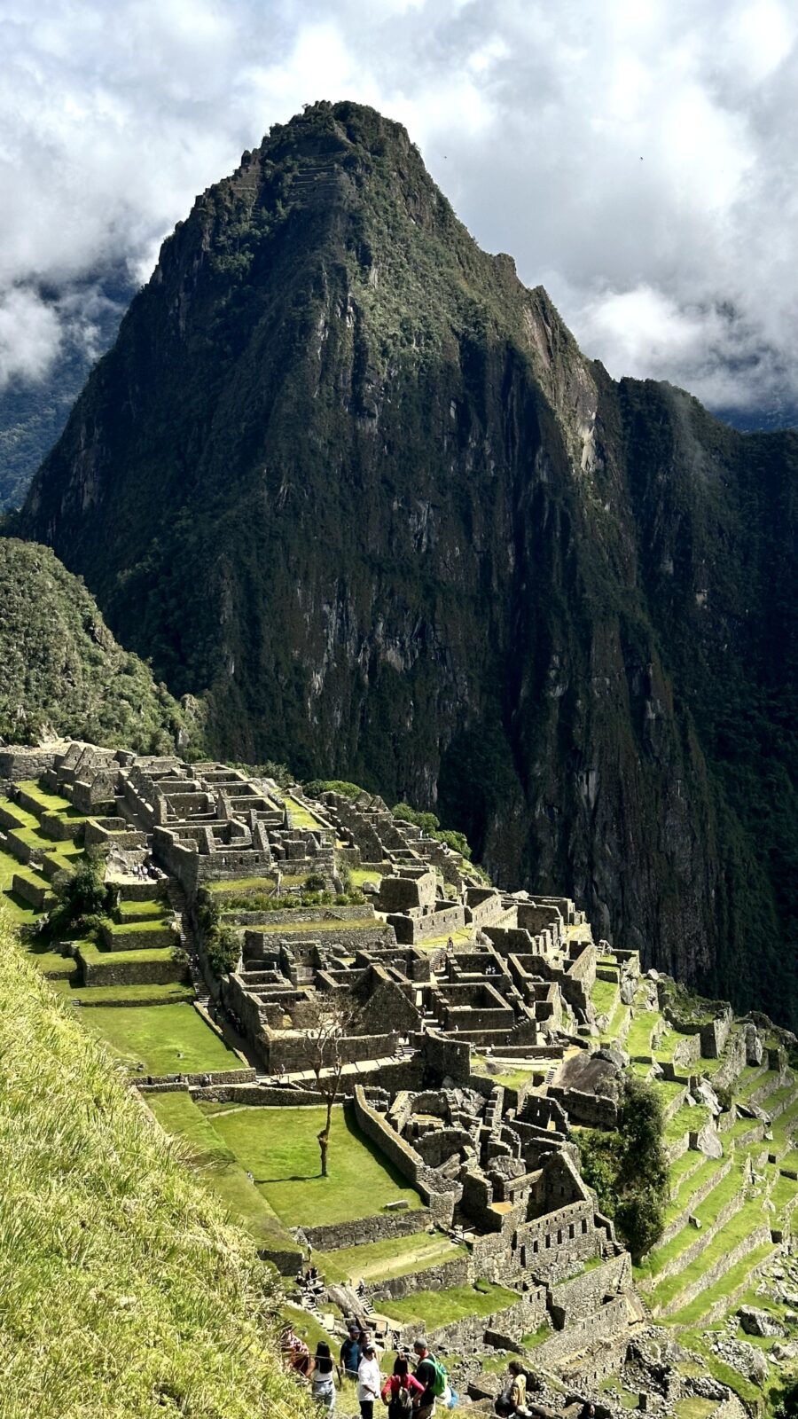 imagem a distância de machu picchu com o monumento histórico e um cume ao fundo