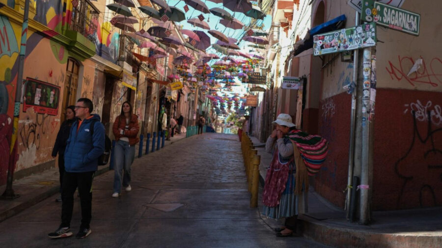 Mercado das Bruxas em La Paz, com guarda-chuvas suspensos e pessoas nas lojas de calçadas