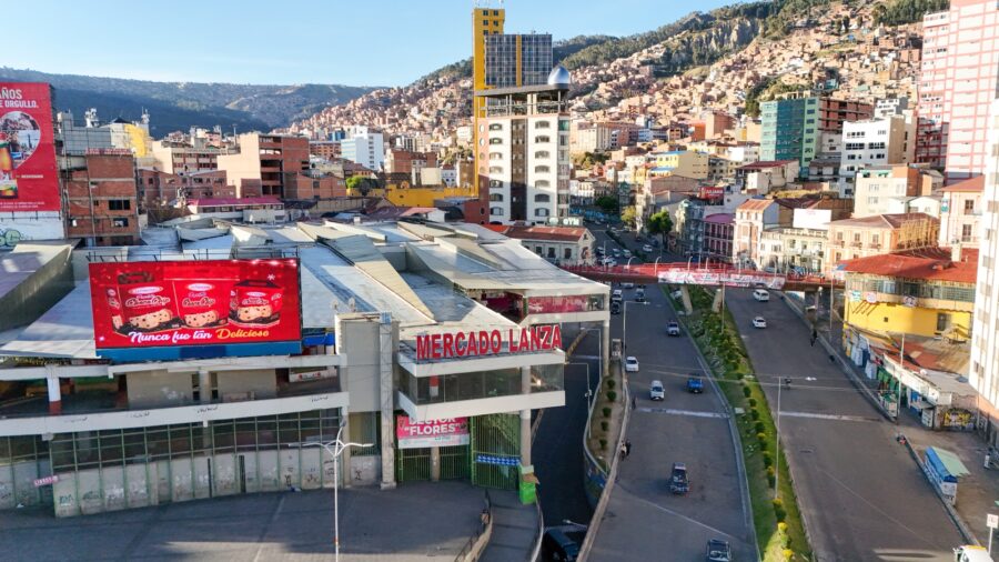 avenida principal em la paz, na bolivia, com restaurantes e varios veiculos transitando