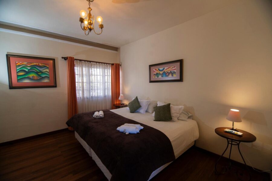 quarto bem aclimatado com uma cortina fechada e uma cama coberta com lençois e travesseiros