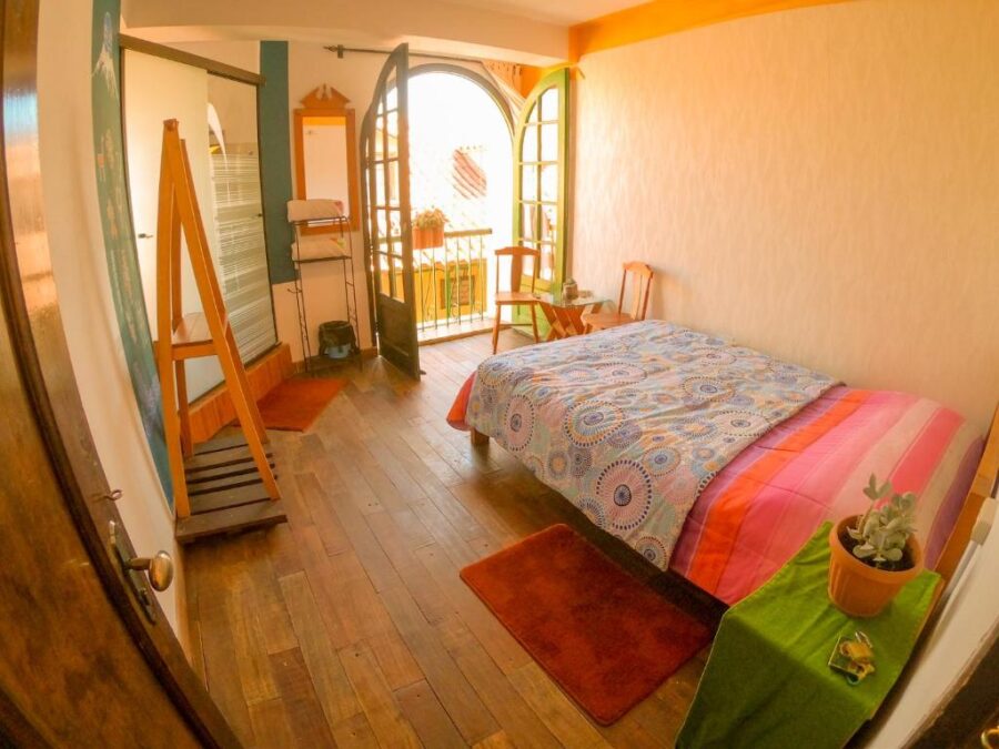 quarto iluminado com um organizador, cama e varanda aberta