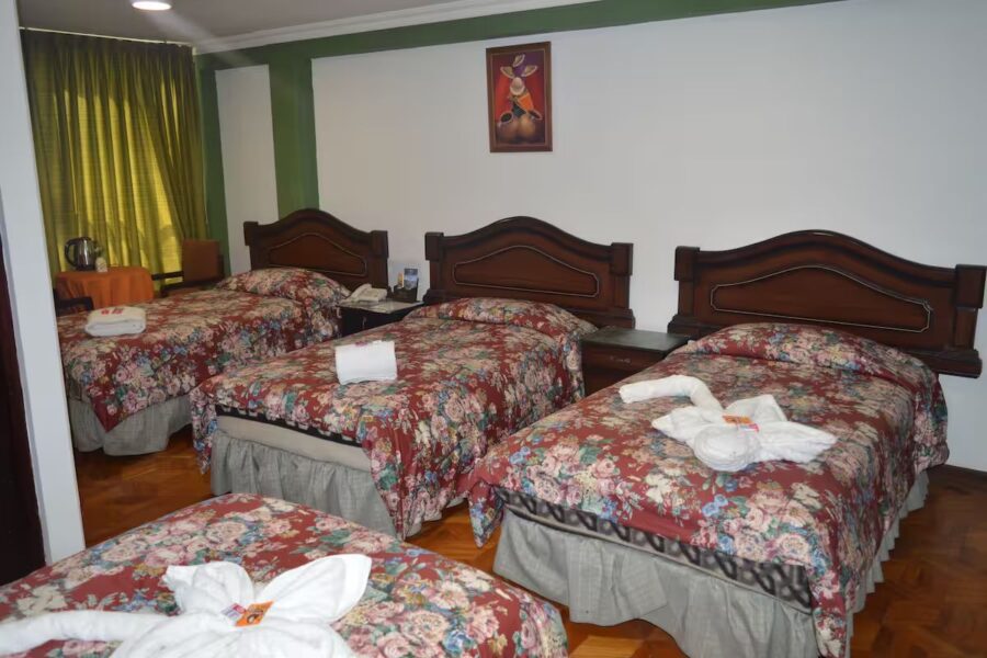 quarto rustico com varias camas solteiro cobertas com edredons