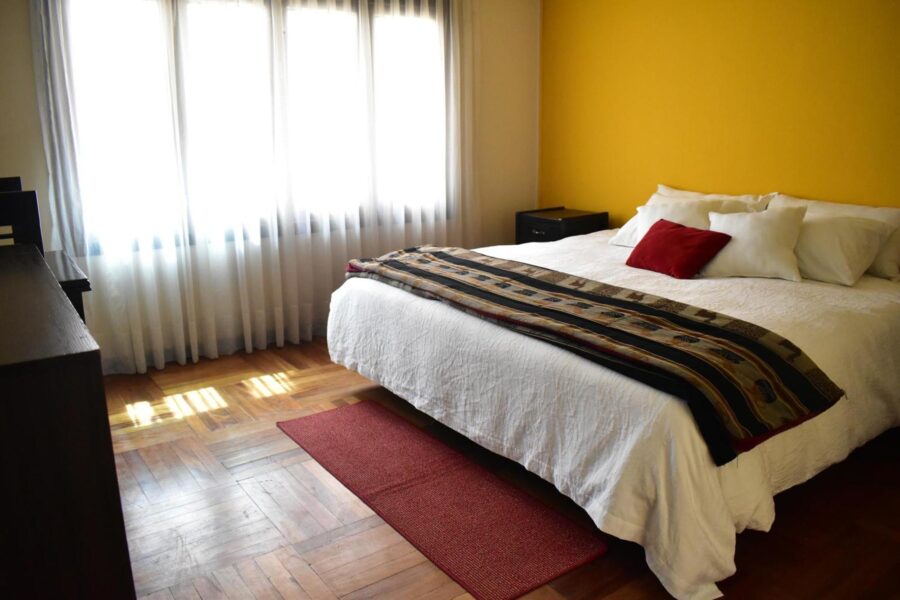 quarto com uma cortina cobrindo a janela e uma cama casal