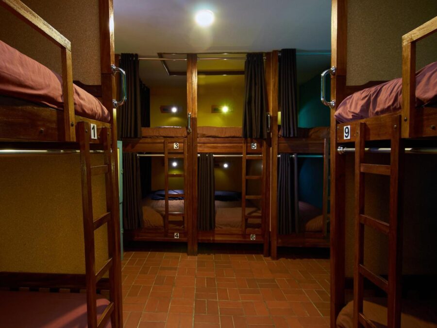 quarto com varias beliches e piso de madeira
