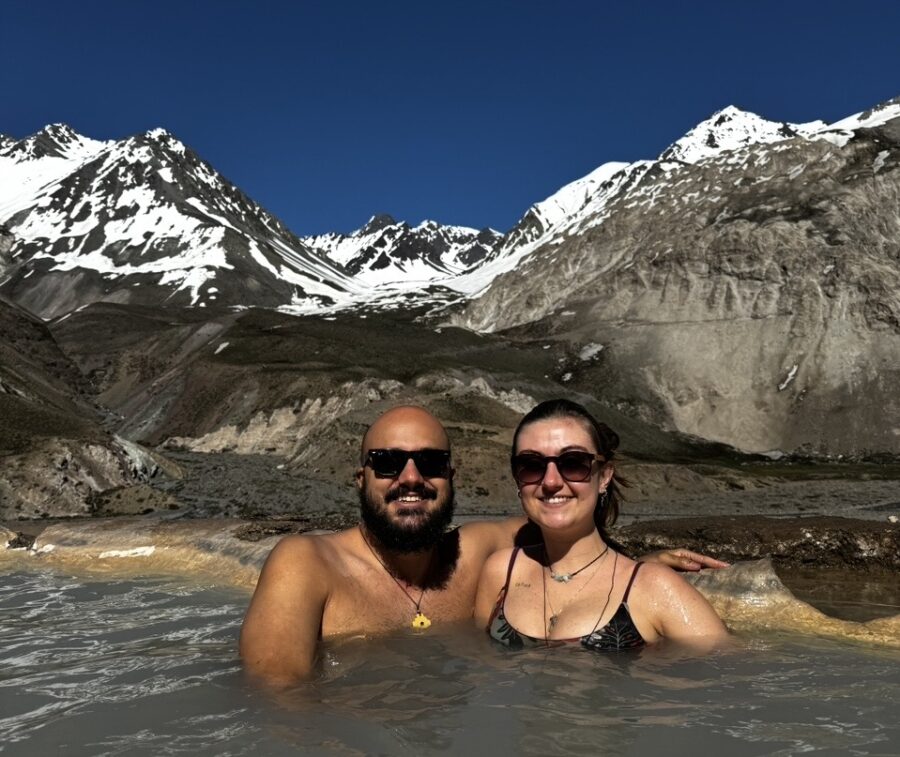 Piscina termal nos Andes próximas a Santiago, com casal em lua de mel relaxando em meio às montanhas.