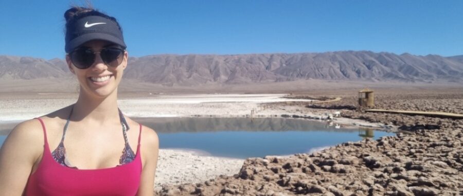 Mulher com paisagem andina ao fundo, sorrindo com óculos-escuros, em viagem com a Fui Gostei Trips