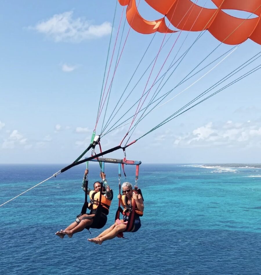 Duas pessoas praticando parasailing sobre o mar azul-turquesa durante um dos passeios em San Andrés