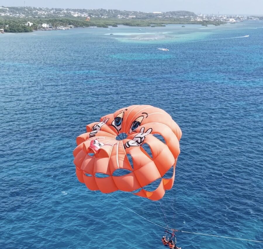 Parasail em San Andrés: paraquedas laranja visto de cima, voando sobre o mar de sete cores