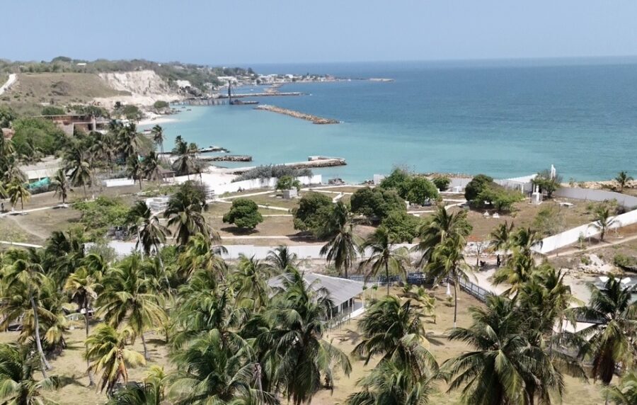 Vista panorâmica de Palmarito Beach, em Cartagena, com mar azul-turquesa, coqueiros, píeres e uma faixa de areia tranquila, mostrando um cenário ideal para quem planeja conhecer Cartagena com crianças e busca um beach club com ambiente mais reservado e contato com a natureza