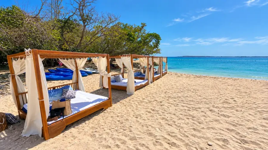 Praia paradisíaca com mar azul-turquesa, areia clara e balde com bebidas e limão em Isla Corona em Cartagena