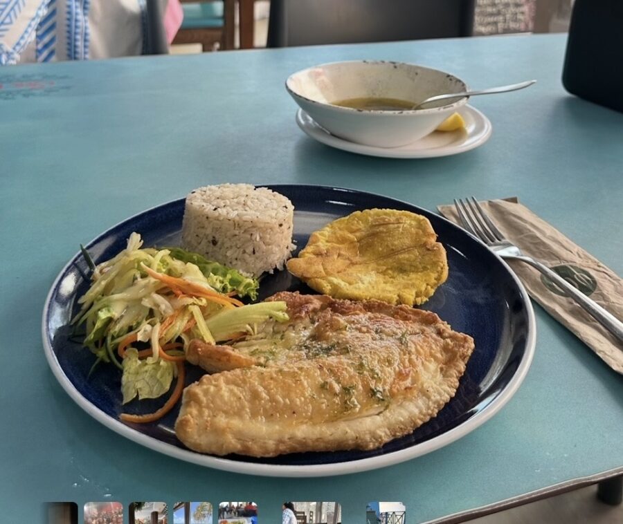 Prato de peixe frito, arroz de coco, salada e patacones em uma mesa azul, destacando a gastronomia em San Andrés