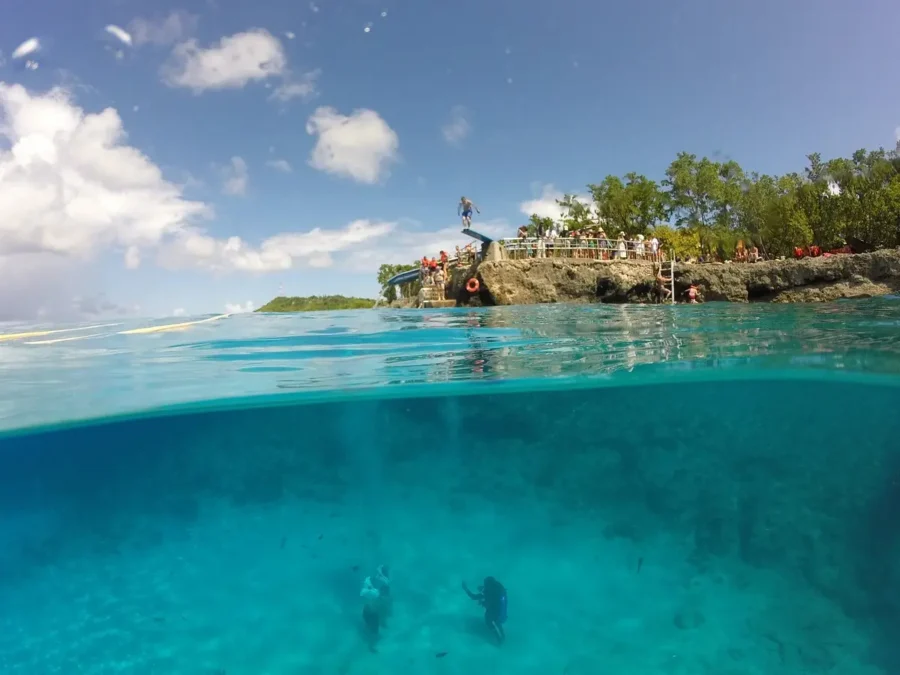 Visão dividida entre o céu e o mar cristalino de um passeio de Aquanautas em San Andrés, com pessoas na costa