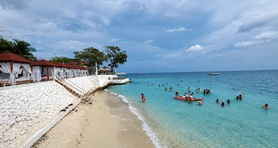 Praia do Bora Bora Beach Club em Cartagena, com cabanas privativas de cortinas brancas, faixa de areia clara e visitantes aproveitando o mar azul-turquesa do Caribe colombiano